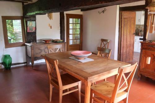 une salle à manger avec une table et des chaises en bois dans l'établissement La Petite Haie, à Bonneville-la-Louvet