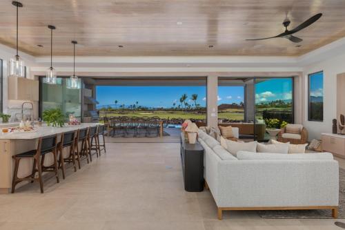 an open kitchen and living room with a view of the ocean at 5BD Mauna Lani Lux Golf Estate (4) at One Ocean in Waikoloa