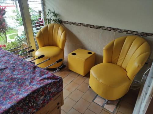 two yellow chairs and a table in a room at Casa Victoria in San José