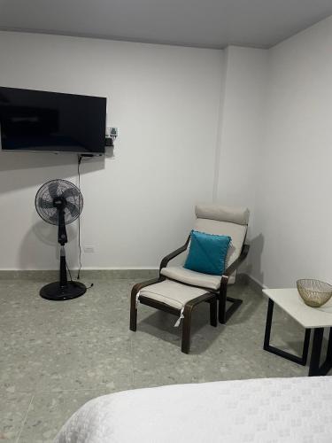 a room with a chair and a fan and a television at Casa Selva in San Carlos
