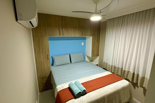 a small bedroom with a bed with a blue headboard at T501 - Apto Novo Ar cond Cama Queen Vaga in Vitória