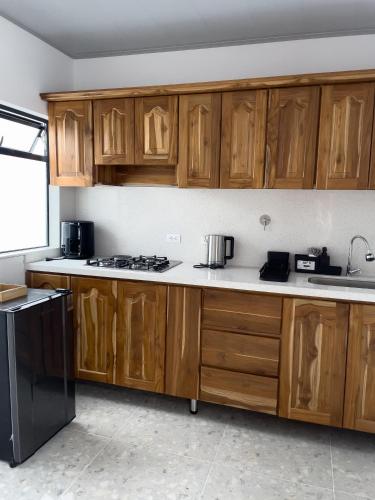 a kitchen with wooden cabinets and a black refrigerator at Casa Selva in San Carlos
