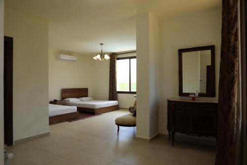 a bedroom with two beds and a mirror and a chair at LaForge Resort 