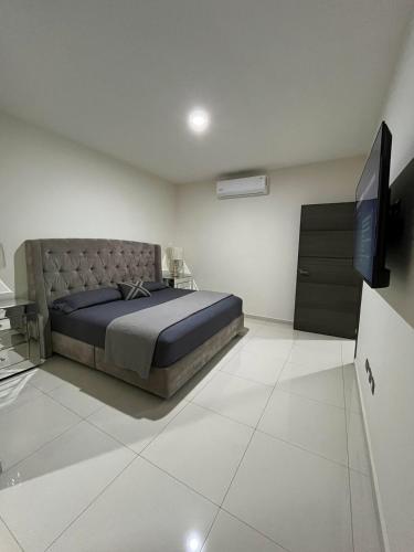 a bedroom with a bed and a flat screen tv at QA Departamento de lujo en primer piso en Quintas in Culiacán