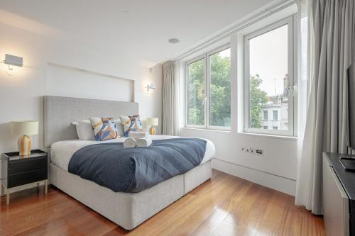 a bedroom with a bed and a large window at Harrods Platinum Pad in London