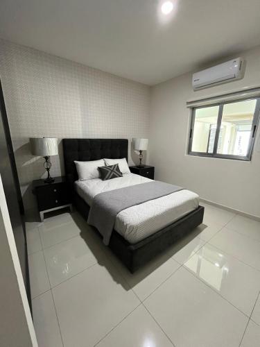 a bedroom with a bed and two lamps and a window at QA Departamento de lujo en primer piso en Quintas in Culiacán