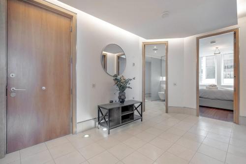 a room with a door and a table with a mirror at Harrods Platinum Pad in London