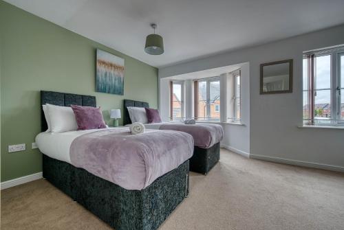 two beds in a bedroom with green walls and windows at Fantastic CONTRACTOR ACCOMMODATION - 5 Bedrooms and driveway! in Coventry