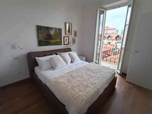 a bedroom with a bed with white sheets and a window at La Cornice nel Centro-503 in Varese