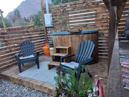 two chairs and a table on a wooden deck at Casa Refugio en Rivadavia in Vicuña
