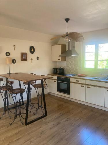 une cuisine avec des armoires blanches et une table en bois dans l'établissement Le linele, à Handschuheim