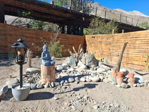 a garden with a statue and rocks in the sand at Casa Refugio en Rivadavia in Vicuña