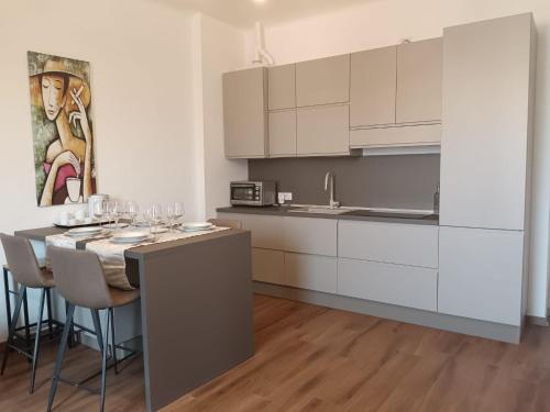 a kitchen with white cabinets and a table with wine glasses at La Cornice nel Centro-503 in Varese