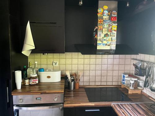 a kitchen with black cabinets and a counter top at Zelena Oaza nadomak Beograda in Lipovica