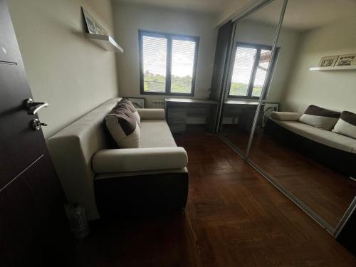 a living room with a couch and a mirror at Zelena Oaza nadomak Beograda in Lipovica