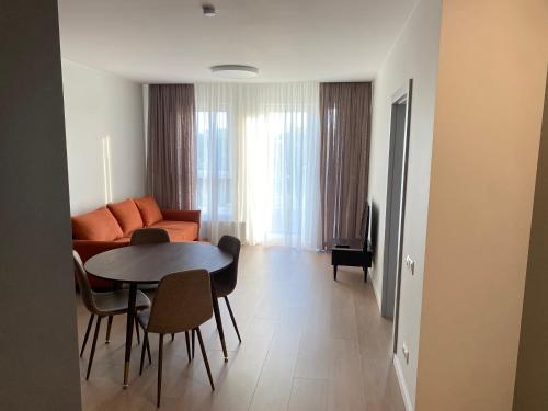 a living room with a couch and a table at Luxury HOLLYWOOD Apartments in Melnragė