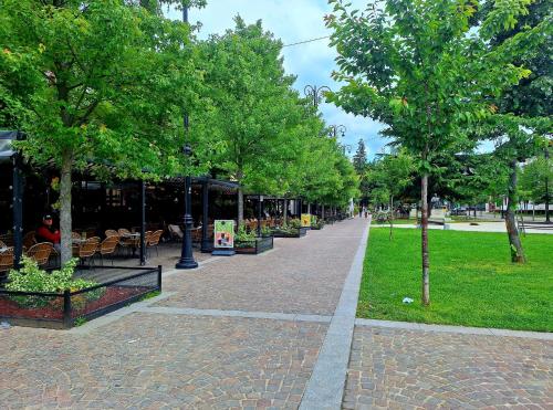 a sidewalk with trees in a park with a building at Apartment Kajon in Peje
