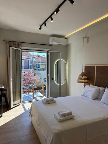 a bedroom with a bed with towels on top of it at Caruso Central Apartments in Lefkada