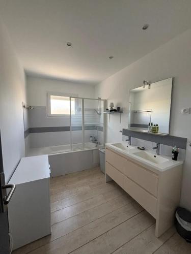 une salle de bain avec deux lavabos, une baignoire et un miroir dans l'établissement Villa familiale avec piscine à Flaux, 125 m²_2, à Flaux