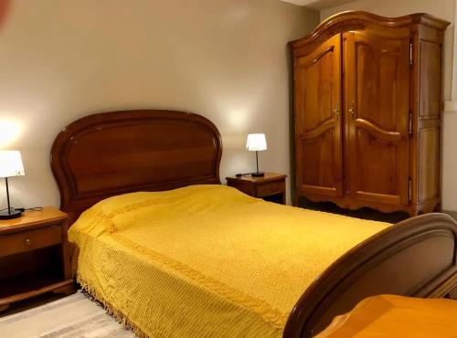 - une chambre avec un grand lit et une armoire en bois dans l'établissement Appartement cosy à Labruguière - 60 m² avec parking_2, à Labruguière