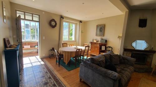 SantecにあるAgréable maison, au Dossen, à 2 pas de la plageのソファとテーブルのあるリビングルーム