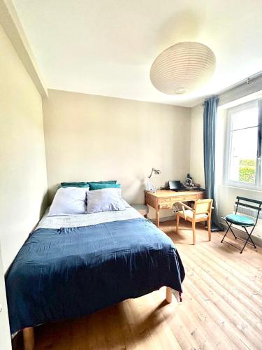 une chambre avec un lit, un bureau et une fenêtre dans l'établissement Agréable maison, au Dossen, à 2 pas de la plage, à Santec