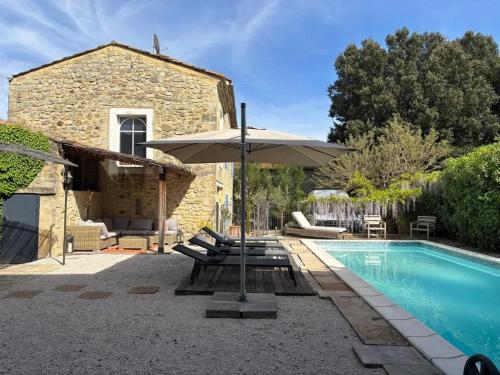 un patio avec un parasol et une piscine dans l'établissement Villa familiale avec piscine privée à Bourdic_2, à Bourdic
