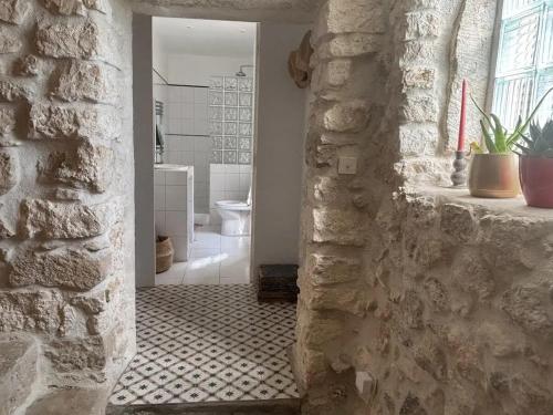 Cette chambre est dotée d'un mur en pierre et d'une salle de bains avec des toilettes. dans l'établissement Villa familiale avec piscine privée à Bourdic_2, à Bourdic