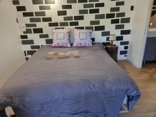 een slaapkamer met een bed met paarse lakens en kussens bij Chez Marilou in Arcens
