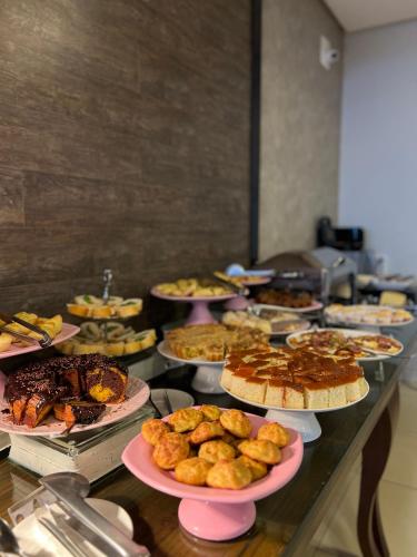 a buffet line with many different types of food on plates at Hotel Relicário in Araguaína