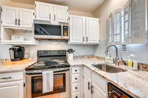 a kitchen with white cabinets and a stove and a sink at 1 Mi to Mohegan Sun Studio with Pool Access in Norwich