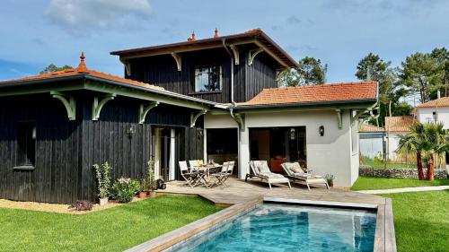 une maison avec une piscine dans la cour dans l'établissement Le Clos des Pins, à Andernos-les-Bains