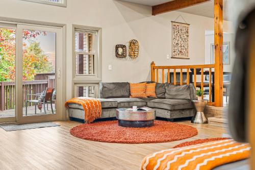 a living room with a couch and a table at Emerald Bluff by AvantStay Lake Views Deck Fire Pit Game Room in Long Pond