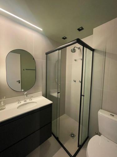 a bathroom with a shower and a sink and a mirror at Madrid Apartment in São Paulo