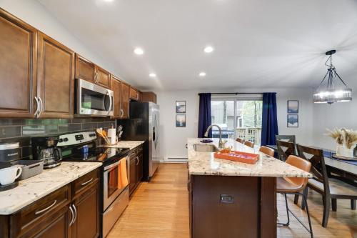 a large kitchen with wooden cabinets and a dining room at Moshannon Tree-Lined Pocono Retreat w Hot Tub Firepit Pool Table in Pocono Lake