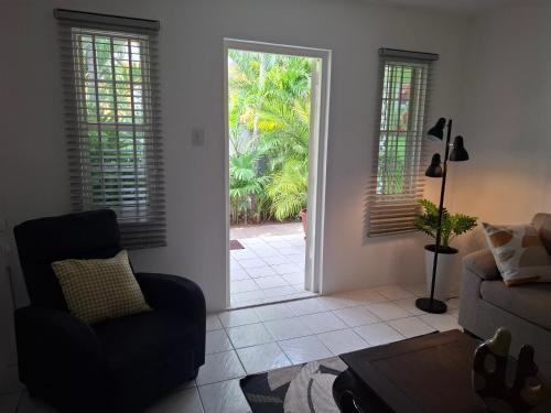 a living room with a door open to a patio at Tropical Palm Retreat in Willemstad