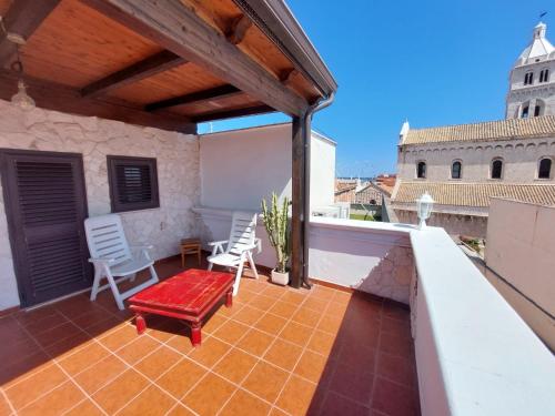 a patio with chairs and a bench on a roof at Tina's House in Barletta