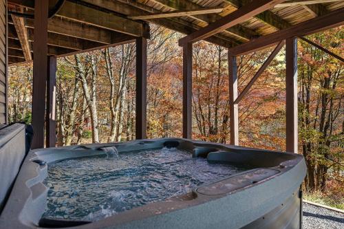 a hot tub sitting inside of a house at Emerald Bluff by AvantStay Lake Views Deck Fire Pit Game Room in Long Pond