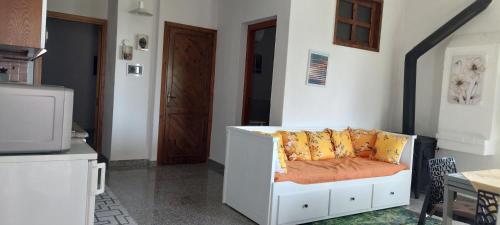 a living room with a white couch with yellow pillows at Sa Mesaluna Naturhouse in Ilbono