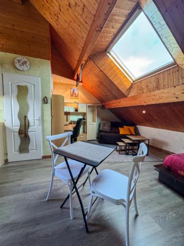 une table et des chaises dans une pièce avec une fenêtre dans l'établissement Appartement Bainville Sur Madon, à Bainville-sur-Madon