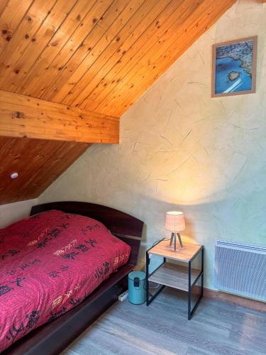 une chambre avec un lit et une table avec une lampe dans l'établissement Appartement Bainville Sur Madon, à Bainville-sur-Madon