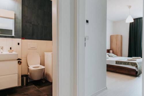 a small bathroom with a toilet and a bed at Apartament Nord One in Timişoara