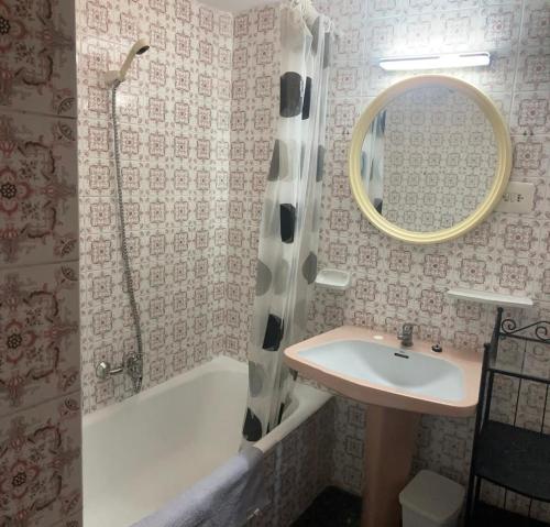 a bathroom with a sink and a tub and a mirror at Résidence El Prado in Cullera