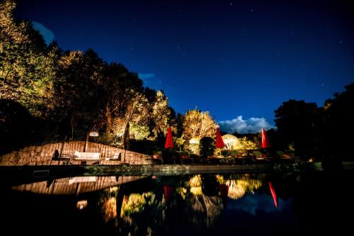 a night view of a park with a pond at Villa 6 personnes avec piscine partagée in Conca
