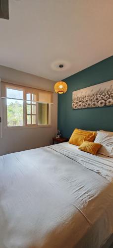 a bedroom with a large white bed with a green wall at Pipas Apartment I Walk to the beach in Tamarindo