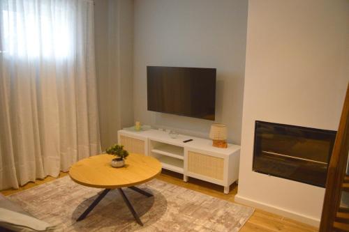 un soggiorno con tavolo e TV a schermo piatto di Casa da Tecas a Vila Nova de Gaia