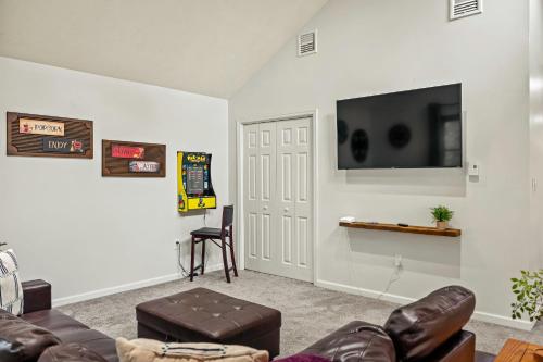 a living room with a couch and a tv on a wall at Rustic-Chic Escape w Hot Tub Fireplace Nature Views Pine Woods Loft in Lehigh