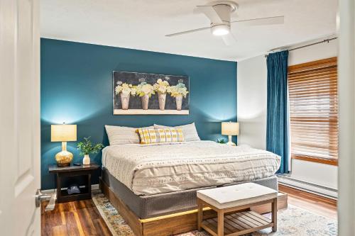 a bedroom with a bed and a blue wall at Rustic-Chic Escape w Hot Tub Fireplace Nature Views Pine Woods Loft in Lehigh