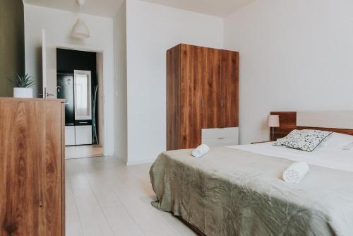 a bedroom with a bed and a wooden cabinet at Apartament Nord One in Timişoara