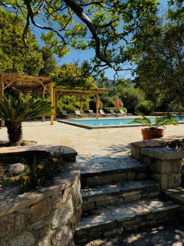 une piscine avec un mur en pierre et des escaliers dans une cour dans l'établissement Villa 6 personnes avec piscine partagée, à Conca